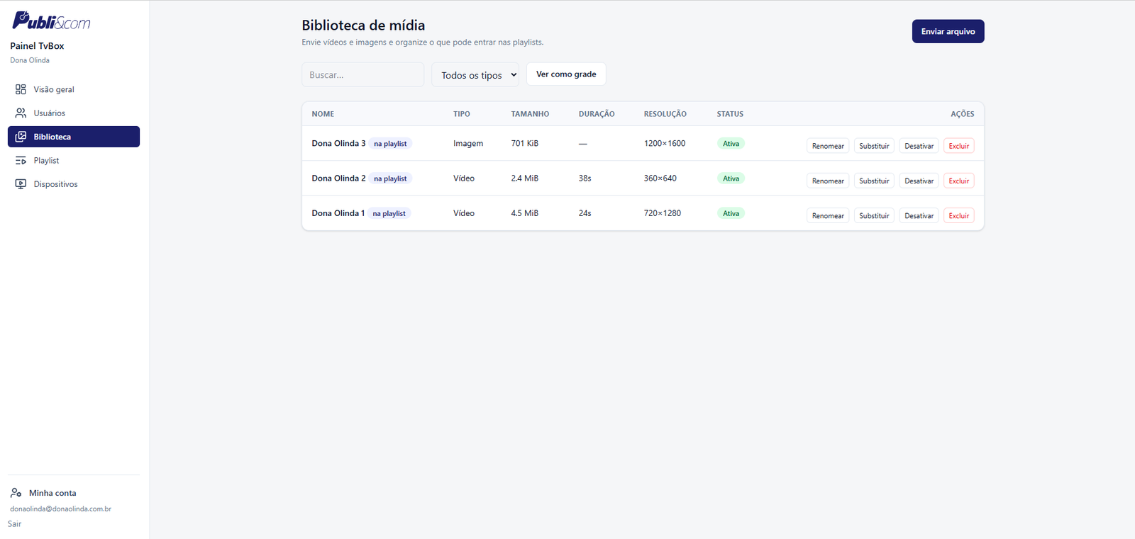 Tela da biblioteca de mídia do painel, com lista de arquivos, tipo, tamanho, duração, resolução, status e ações como renomear, substituir, desativar e excluir.